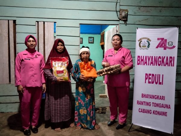 Ketua ranting Bhayangkari Polsek Tongauna, Ny. Riny Fajar (Kiri) saat menyalurkan bantuan sembako kepada keluarga pra sejahtera.